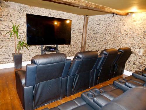 a room with leather chairs and a flat screen tv at Huge Luxury 8 Bed Manor House Hot Tub Pool Table in Saffron Walden