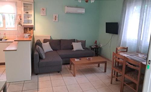 a living room with a couch and a table at Carpe Diem near the Athens airport in Markopoulo