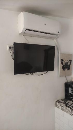 TV de pantalla plana colgada en la pared en Casita con mirador, en Málaga