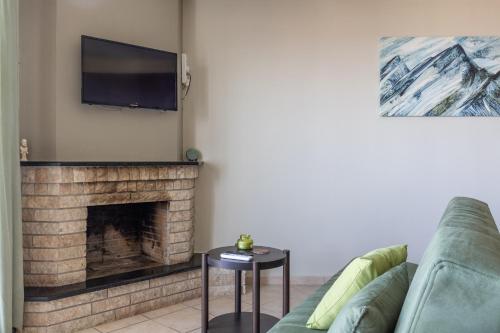 a living room with a couch and a fireplace at Mar y Montaña Apartments Litochoro in Litochoro