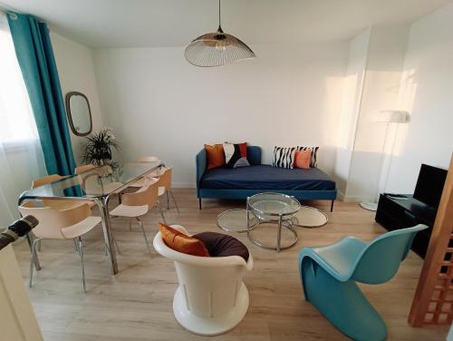 a living room with a blue couch and chairs at Chelles centre ville 2 chambres près des bords de Marne 10 minutes à pieds de la Gare de Chelles-Gournay 5 minutes de la gare de Vaires-sur-Marne 20 minutes de Disneyland jusqu'à 5 couchages possibles in Chelles