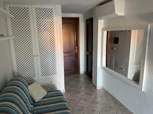 ein Wohnzimmer mit einem Sofa und einem Spiegel in der Unterkunft Monolocale Cala Reale in Marinella