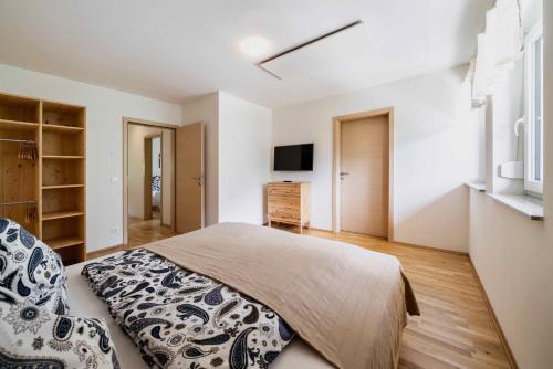 a bedroom with a bed and a tv on a wall at 1Schönes Ferienhaus im sonnigen Kärnten in Döbriach