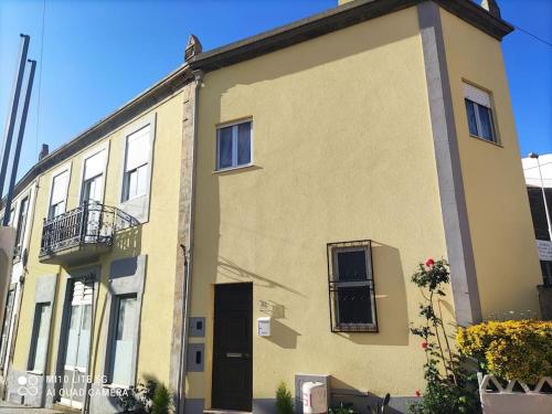 ein gelbes Gebäude mit Balkon auf einer Straße in der Unterkunft Casa do Trovão - Douro in Peso da Régua