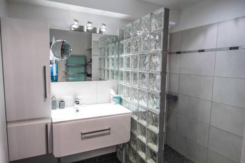 a white bathroom with a sink and a mirror at Appartement avec jardin intérieur 4 pers centre ville in Nemours