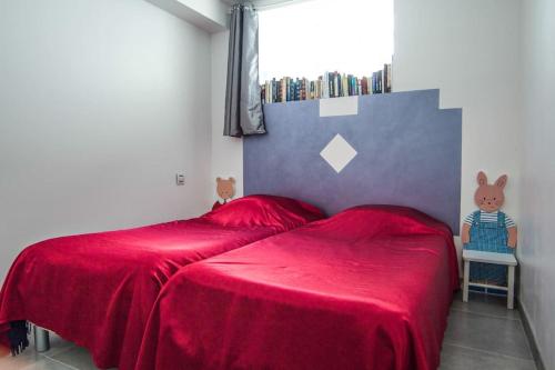 a bedroom with a red bed with a red blanket at Appartement avec jardin intérieur 4 pers centre ville in Nemours