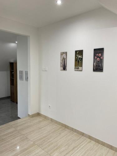 a room with white walls and pictures on a wall at Apartma Azurre in Postojna
