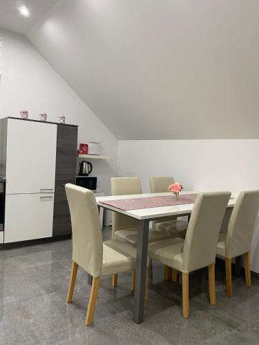 a dining room with a table and chairs and a refrigerator at Apartma Azurre in Postojna