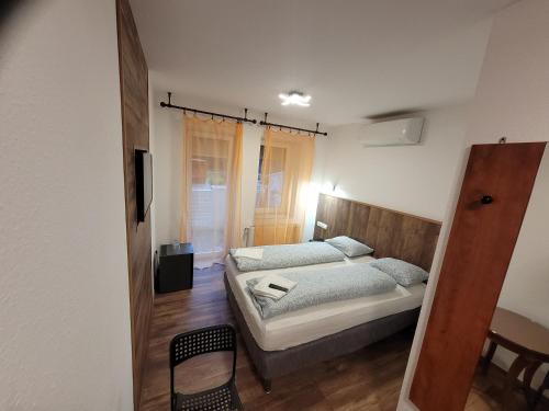 ein Schlafzimmer mit einem Bett und einem Tisch mit einem Stuhl in der Unterkunft Kiskunlacháza 6 in Kiskunlacháza