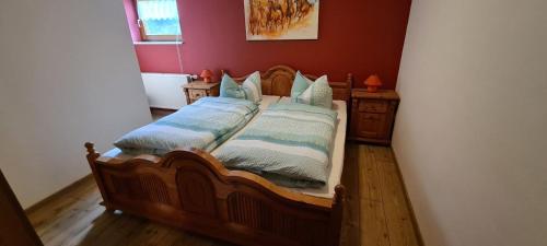 a bedroom with a wooden bed with pillows at Ferienwohnung Fleischer in Langenwetzendorf