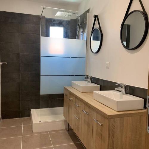 une salle de bain avec deux lavabos et deux miroirs dans l'établissement Maison de village 150 M2 au calme climatisée, piscine, à Rasteau