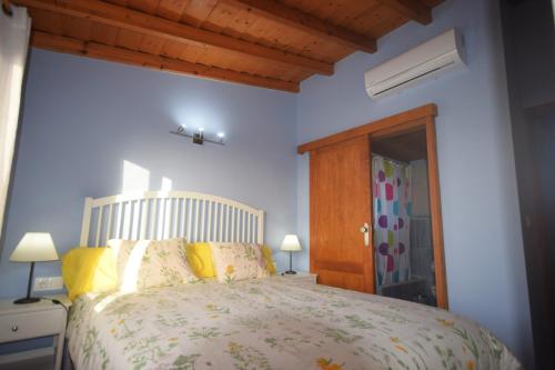 Un dormitorio con una cama grande con almohadas amarillas. en Casa Florita, en Puntagorda