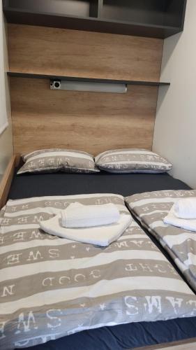 Una cama con dos almohadas encima. en Mobile Home Livanda, en Klenovica