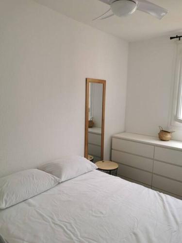 une chambre avec un lit blanc et un miroir dans l'établissement Superbe appartement à 40 mètres de la plage, à Canet