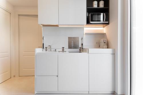 a kitchen with white cabinets and a microwave at Il Mama House in Termoli