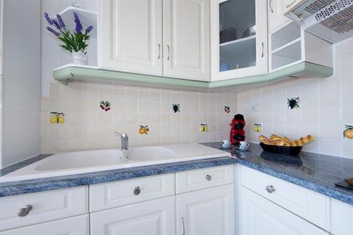 a kitchen with white cabinets and a sink at Piso Sofia in Empuriabrava