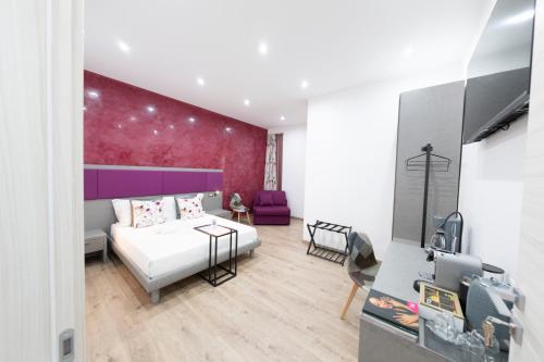 1 dormitorio con cama blanca y pared morada en Catone Luxury Rooms, en Roma
