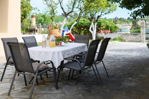 a table with black chairs and a white table cloth at Villa Armeni by CorfuEscapes in Corfu