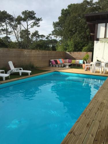 a swimming pool with blue water in a backyard at Maison avec Piscine Labenne Ocean in Labenne