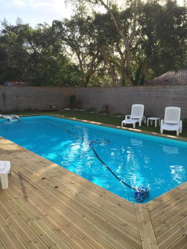 a swimming pool with a water hose in a yard at Maison avec Piscine Labenne Ocean in Labenne