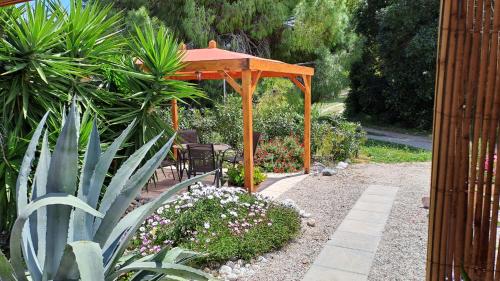 a wooden gazebo in a garden with plants at Villa Soroni in Soroni