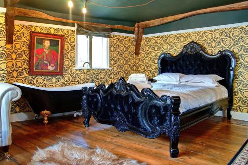 a bedroom with a bed and a tub in it at Luxury 9 Bed Manor House Hot Tub Cinema Room SkyTV in Saffron Walden