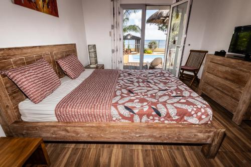 a bedroom with a bed and a view of the ocean at Les Villas 33 Bis in Baie du Tombeau