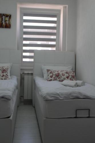 um pequeno quarto com uma cama e uma janela em Red Apartment em Sarajevo