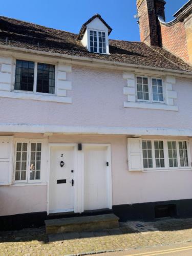 a white house with two white garage doors at Lovely Two Bedroom Town House - Minimum 2 Night Stay in Midhurst