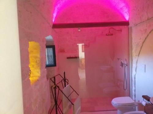 Baño rosa con aseo y techo rosa en Trulli: La pace dei sensi, en Alberobello