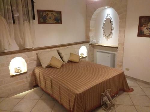 1 dormitorio con 1 cama con 2 almohadas y espejo en Trulli: La pace dei sensi, en Alberobello