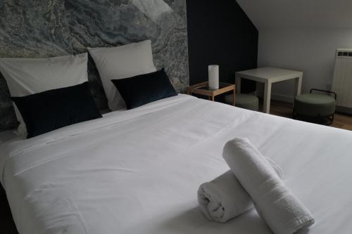 une chambre avec un lit blanc avec des serviettes dessus dans l'établissement Balcon sur Loire, à Blois