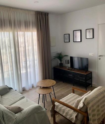 ein Wohnzimmer mit einem Sofa und einem Tisch in der Unterkunft Precioso Apartamento in Puerto de Mazarrón