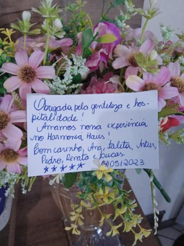 a vase of flowers with a sign on it at loft harmonia in Blumenau