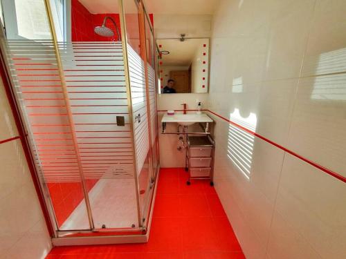 ベナルマデナにあるApartment D with heated swimming pool, jacuzzi, waterfall, heating is extraの赤い床のバスルーム(シンク付)