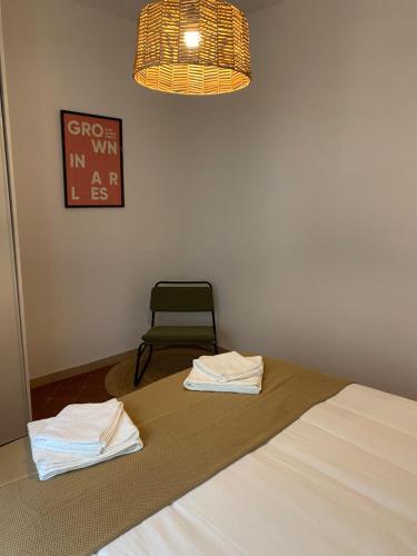 1 dormitorio con 1 cama con silla y lámpara en "Le central" Appart Arles en Arlés