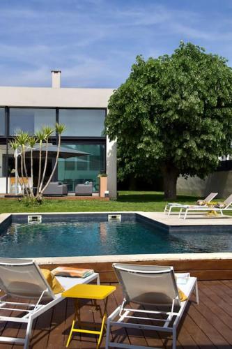 - deux chaises assises à côté de la piscine dans l'établissement Villa Luxe Oasis, à Aubagne