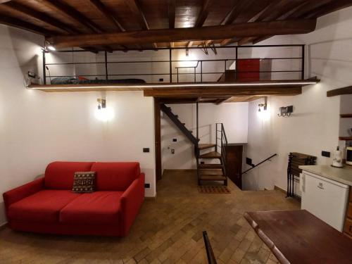 a living room with a red couch and a loft at Il Loft del Lago in Anguillara Sabazia
