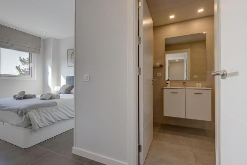 a bedroom with a bed and a bathroom with a sink at Brand new apartment with pool and SEA VIEW in Marbella in Marbella
