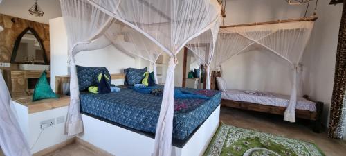 a bedroom with a bed with a canopy at Salama & Mbuyuni Bungalows in Matemwe