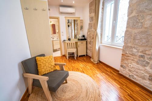 uma sala de estar com uma cadeira e uma parede de pedra em Luxury Rooms Lucija and Luka em Split