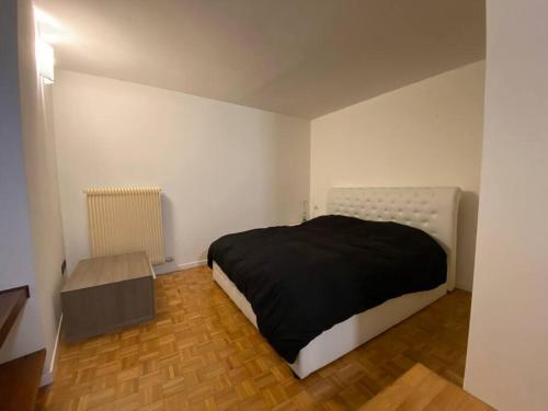 ein Schlafzimmer mit einem Bett in einem weißen Zimmer in der Unterkunft Appartamento a Rovereto in Rovereto