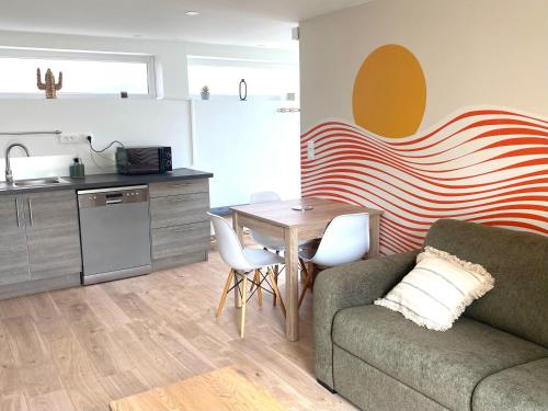a living room with a couch and a table and a kitchen at Gîte proche Colmar vignoble in Wettolsheim