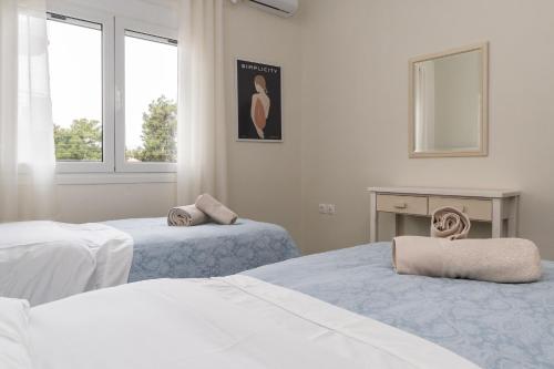 a white room with two beds and two windows at Sissy apartment in Kiaton