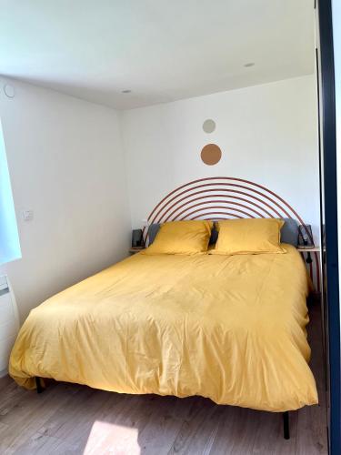 une chambre avec un lit avec un couvre-lit jaune dans l'établissement Gîte proche Colmar vignoble, à Wettolsheim