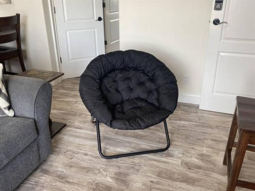 a black chair sitting in a living room next to a couch at Hillside view with hot tub too in Arroyo Grande