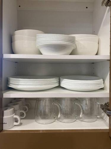a shelf filled with plates and cups and dishes at Hillside view with hot tub too in Arroyo Grande