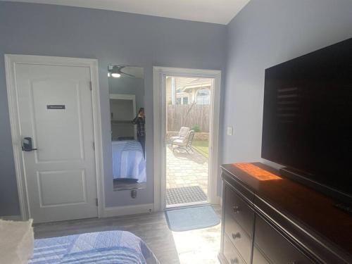 a living room with a tv and a door to a bedroom at Hillside view with hot tub too in Arroyo Grande