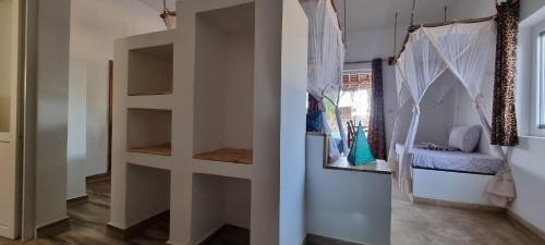 a room with a book shelf and a chair at Salama & Mbuyuni Bungalows in Matemwe
