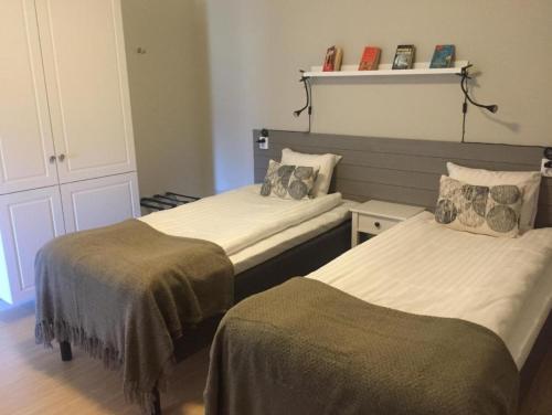 a bedroom with two beds with blankets on them at Närebo Gårdshotell & Restaurang in Lidköping